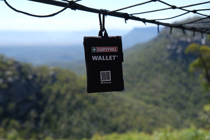 Black Wallet 2.0 hanging from a line with a mountain valley behind it