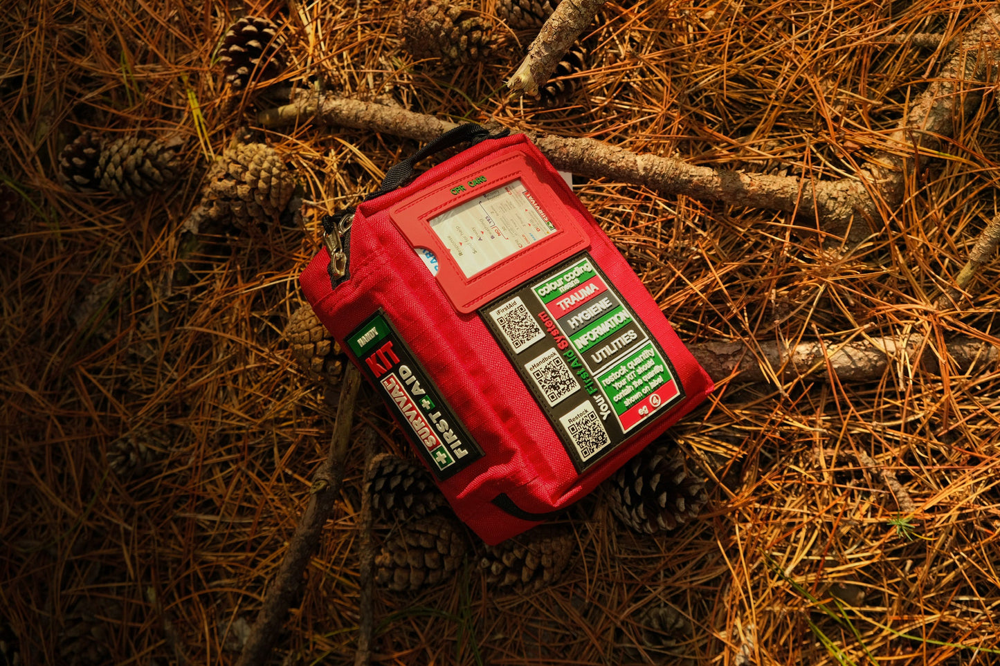 Red Handy case on a forest floor covered with pine needles
