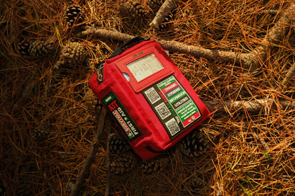 Red Handy case on a forest floor covered with pine needles