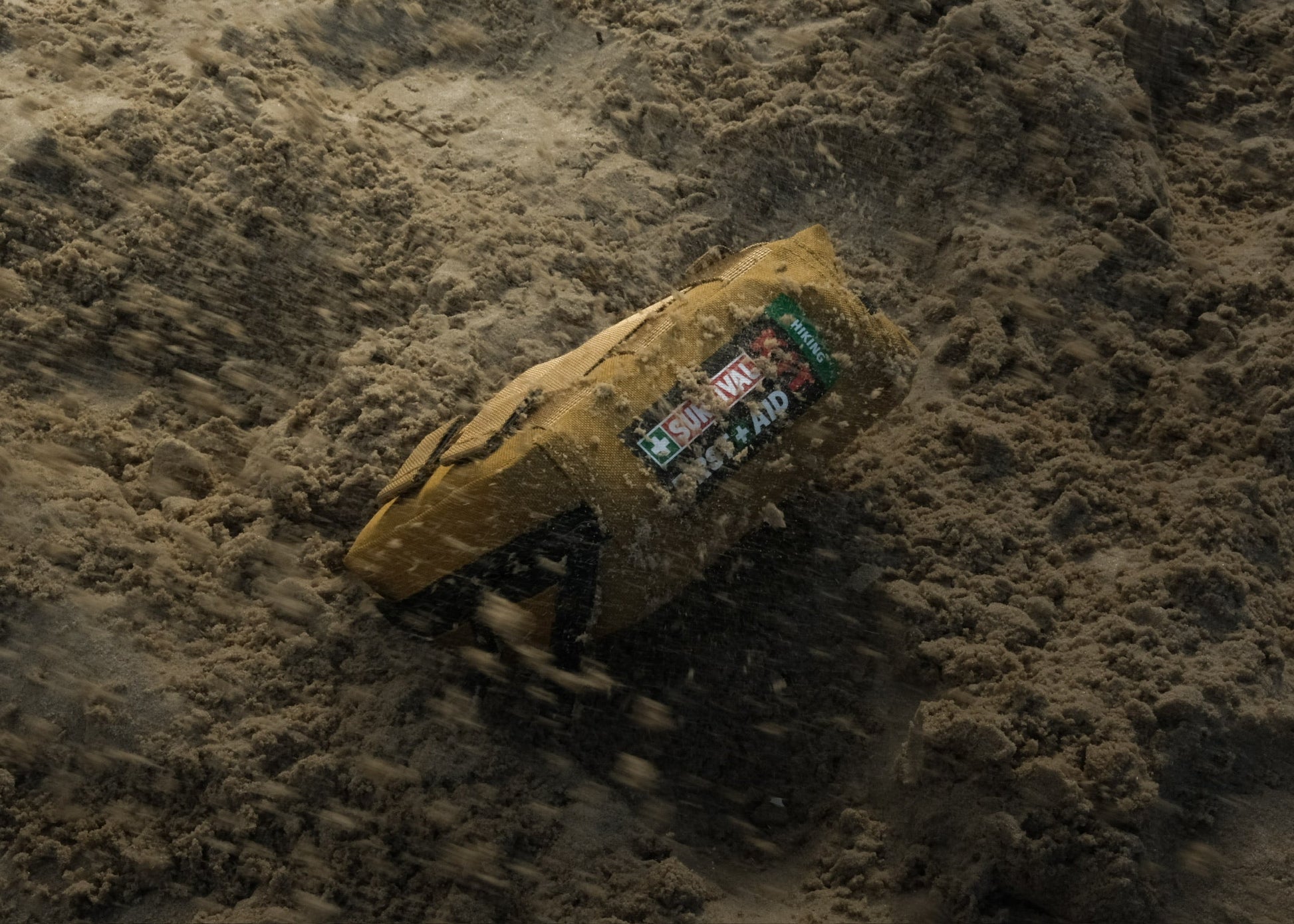 Coyote Hiking kit half buried in sand