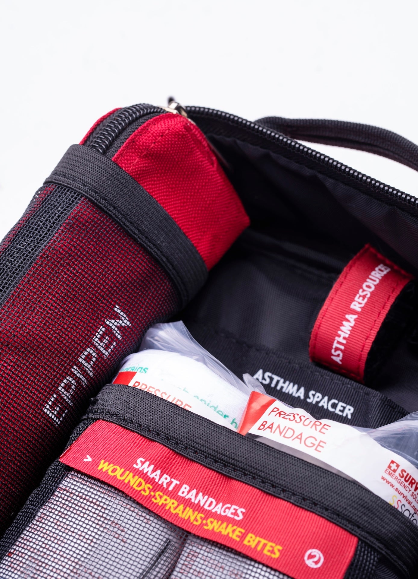 Close-up of the labelled EpiPen and asthma spacer pockets inside the bag