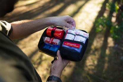 Person holding the opened Snake Bite kit in woodland